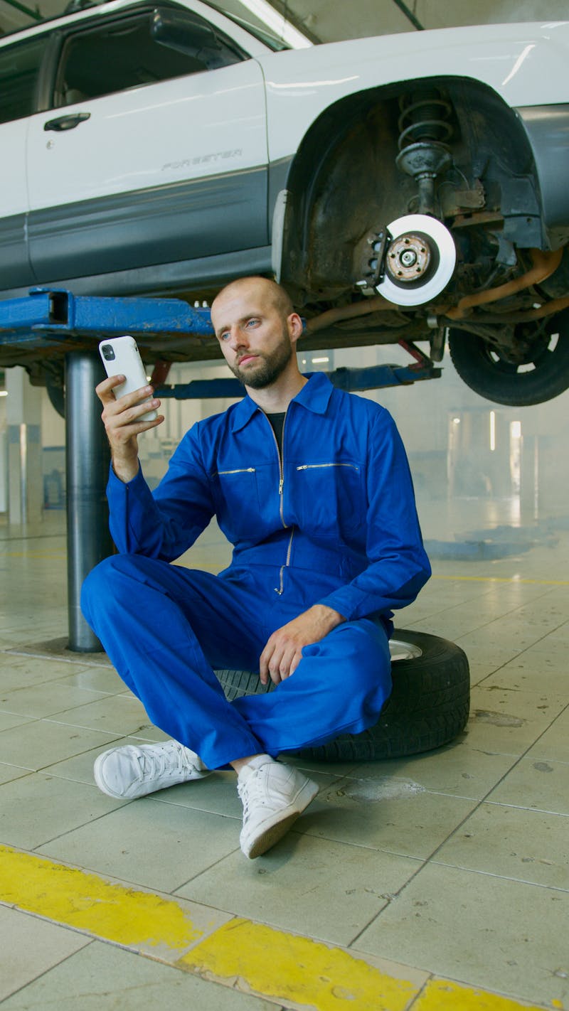 Mechanic photographing vehicle repair in workshop